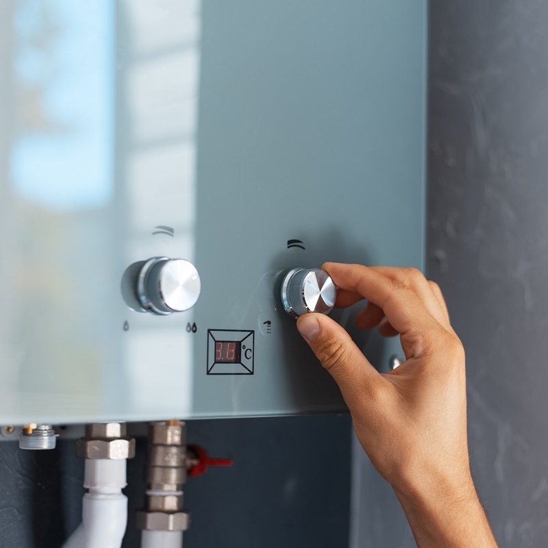Close-up of male hand adjusting temperature of water heater. Modern home gas fired boiler. Instant Electric Geyser Repairing